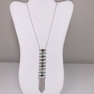 Long silver pendant style necklace with iridescent color round faceted stones.